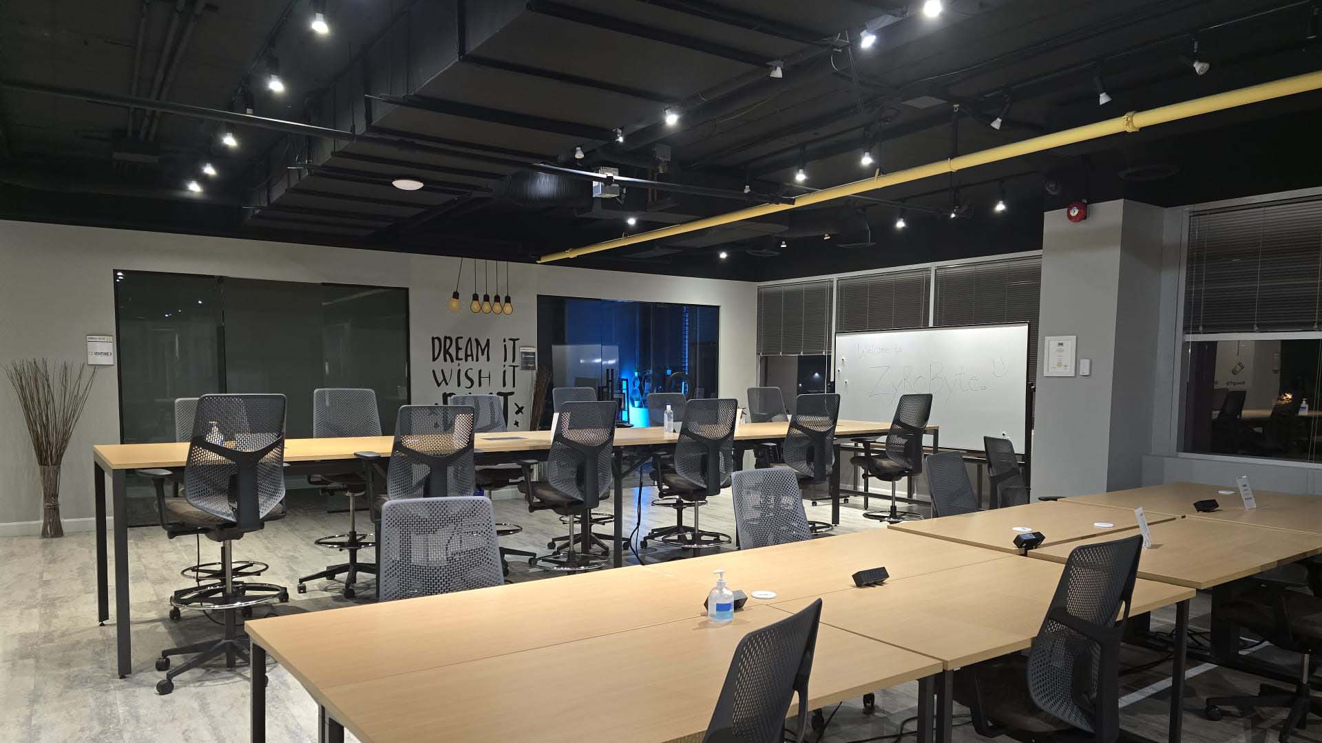 Inside the ZyroByte office, with shared worktables and a whiteboard for planning
